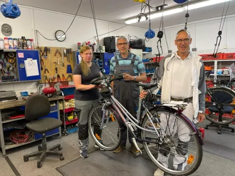 Team der Sozialen Fahrradwerkstatt mit einem reparierten Fahrrad